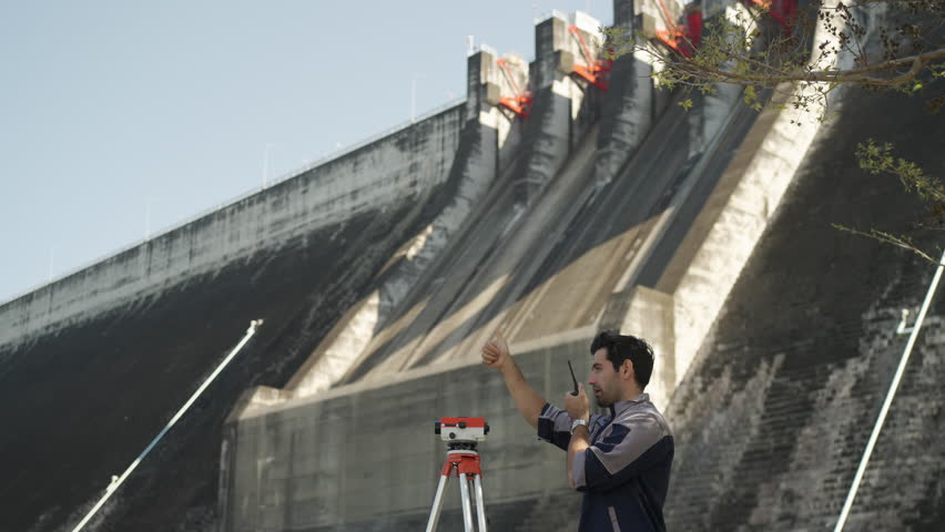 Blue collar worker is working at the dam. Environment, engineering, construction.