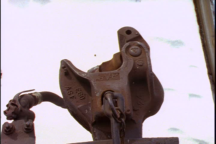 Mid Continent Railway, New Freedom, Wisconsin. Close up of 1885 steam train coupler from overhead. Another coupler moves into shot and hitches itself to the other against snowy background.