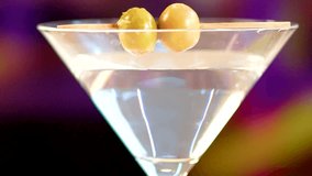 Centered close-up of a clear martini cocktail, garnished with two olives on a toothpick. - Powered by Shutterstock - Get 15% off with code: PIKWIZARD15