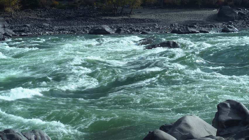 Green River Rapids Crashing Over Rocks With Frothy Foam And Fast Current, Rugged Boulders Lining Shore, Emerald Water Churn, WindWhipped Spray, Dramatic Mountain Setting Ideal For Nature Study