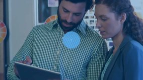 Animation of connected icons over diverse coworkers discussing reports on digital tablet in office. Digital composite, multiple exposure, communication, business, teamwork and technology concept. - Powered by Shutterstock - Get 15% off with code: PIKWIZARD15