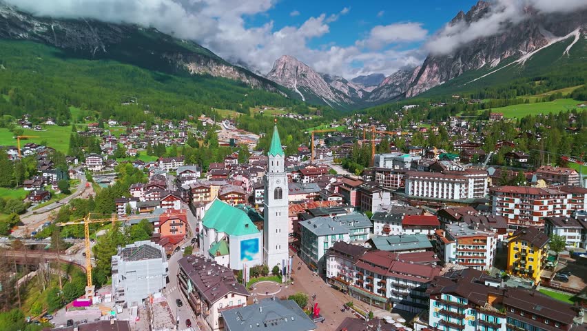 erial view of Cortina d'Ampezzo, Italy, featuring Basilica dei Santi Filippo e Giacomo, a small town in Belluno province, Dolomites mountains, Veneto region, famous for winter holidays.