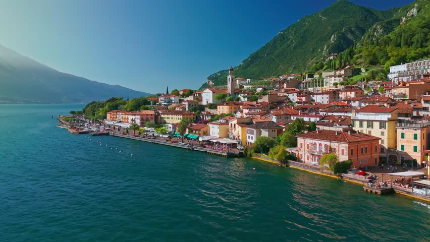 Aerial view of picturesque Limone sul Garda on Lake Garda with summer landscape, alpine shoreline, mountains, ferry boat and scenic travel setting in Northern Italy.