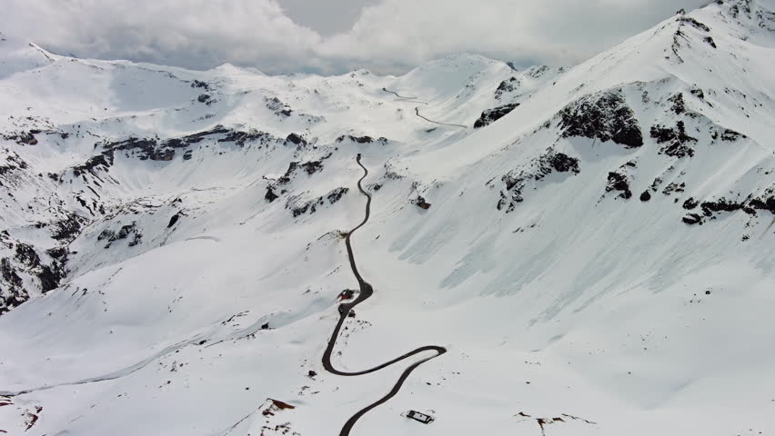 Aerial view of Grossgloknershtrasse in snow. Great high mountain road near Grossglokner mount in Austrian Alps, 4k