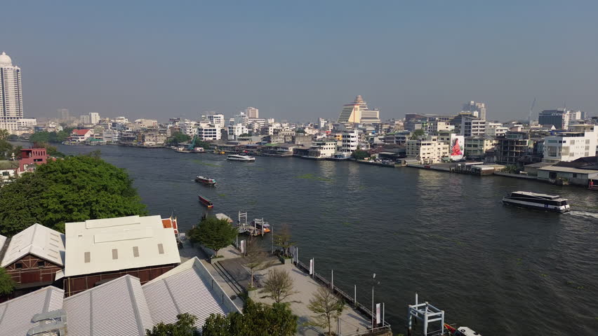 Aerial view of skyscrapers in Bangkok city and boats in Chao Phraya River, 4k