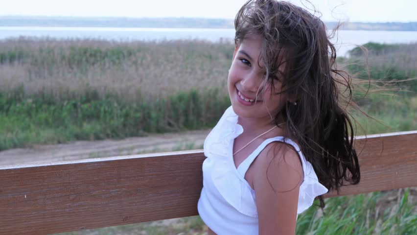 A happy and carefree young girl with her hair blowing in the wind