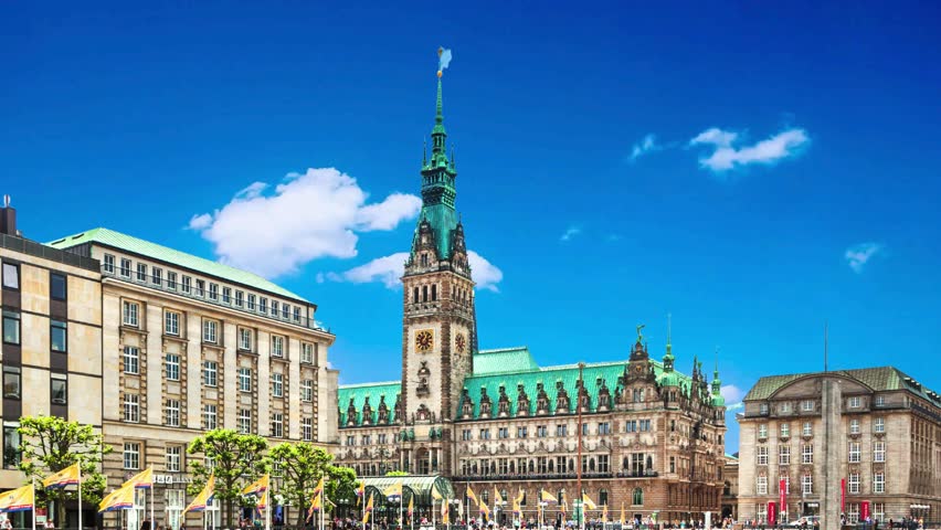 A panoramic view of the Hamburg City Hall  in  Hamburg, Germany with thin clouds backgroundPanorama showing a building of the Hamburg City Hall timelapse, the seat of the government of Hamburg, located in the Altstadt quarter in the city center. View from the main square under a cloudy skyHamburg City Hall or Rathaus is the seat of local government of Germany
