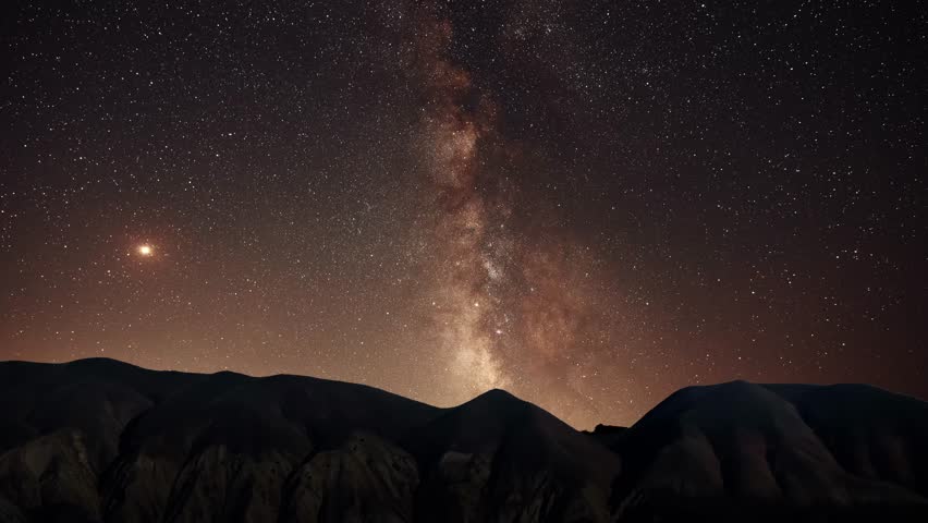 Beautiful night landscape, mountains under colorful bright milky way galaxy at starry night. Time lapse