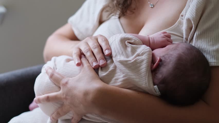 Mother breastfeeding her newborn baby in arms
