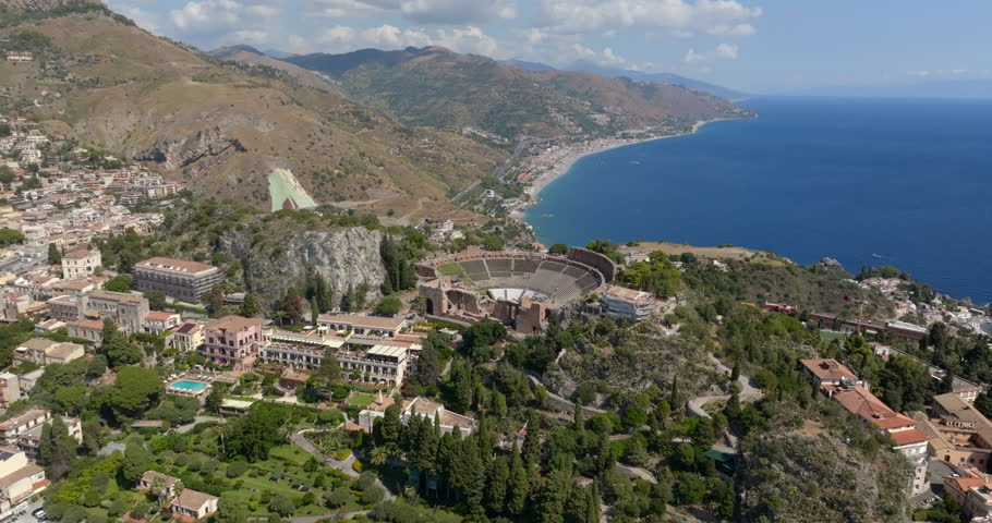 Aerial view of the theater of Taormina, in the province of Messina, Sicily, Italy. These are the ruins of an ancient Hellenistic theater from the Greek period. It is a sunny summer morning.