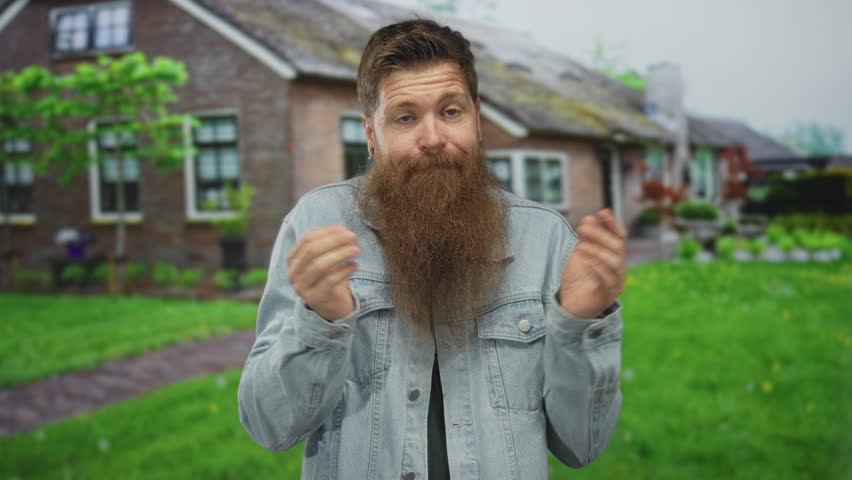 Bearded man shrugs with open hands at mossy brick house entrance amid lush green garden; uncertainty.