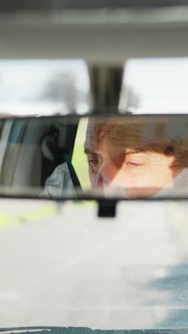 Eyes of a Man Focused on Driving Reflected in the Car Mirror 