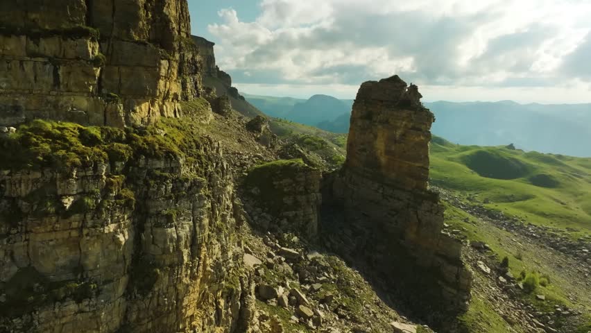 Panoramic aerial shot of the dramatic natural landscape of the Bermamyt plateau in the Karachay-Cherkess Republic, Russia. The footage features the unique rock formation known as the "Rocks of two mon