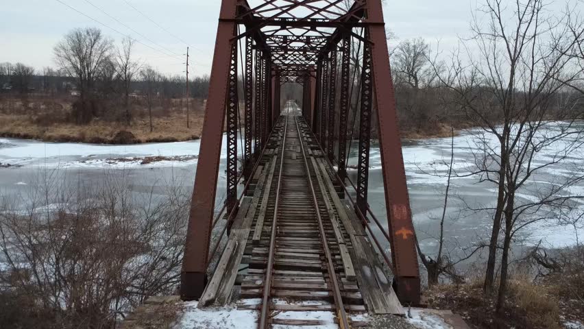Crossing an abandoned train track over a frozen river.