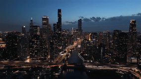 Cinematic aerial night view of Chicago skyline with illuminated skyscrapers, river reflections, glowing streets and modern downtown atmosphere, showcasing urban travel destination and city life - Powered by Shutterstock - Get 15% off with code: PIKWIZARD15