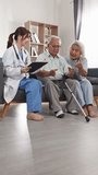 Young asian doctor nurse consults senior couple patient home happy care looking medical result clipboard health support elder people love kindness retirement house living room Vertical Video - Powered by Shutterstock - Get 15% off with code: PIKWIZARD15