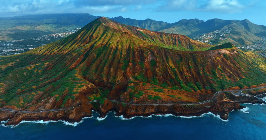 Flight along the spectacular ragged mountain over the waterscape of the Pacific Ocean. View on the Diamond Head Crater in Oahu, Hawaii, USA.