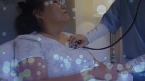 Animation of spots over asian female doctor with patient and stethoscope. Global medicine and digital interface concept digitally generated video. - Powered by Shutterstock - Get 15% off with code: PIKWIZARD15