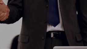 Two businessmen shaking hands in the workplace. Global business data processing digital interface technology and networking concept digitally generated video. - Powered by Shutterstock - Get 15% off with code: PIKWIZARD15