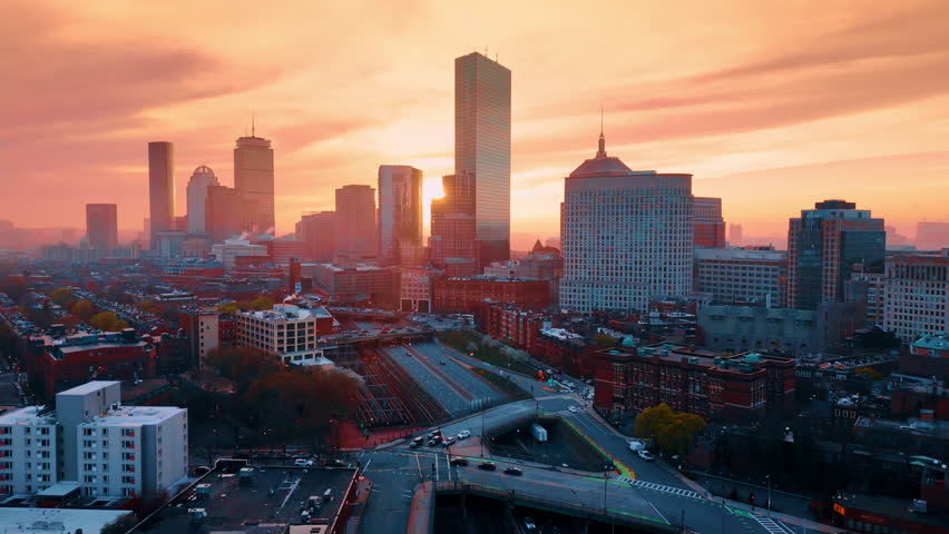 View on the highways and freeways with cars riding by. Downtown of Boston, Massachusetts, USA at sunset. Aerial perspective.