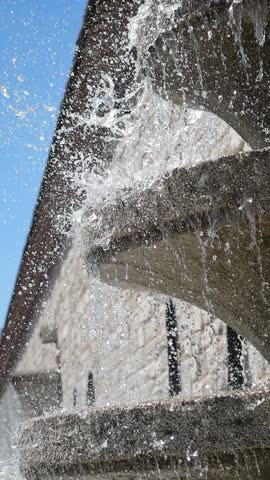 Water cascading from a tiered fountain in a sunny location
