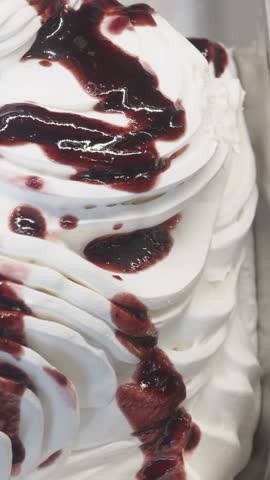 Indulging in creamy dessert topped with sweet sauce and cherries