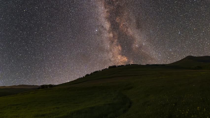 Beautiful night landscape, mountains under colorful bright milky way galaxy at starry night. Time lapse