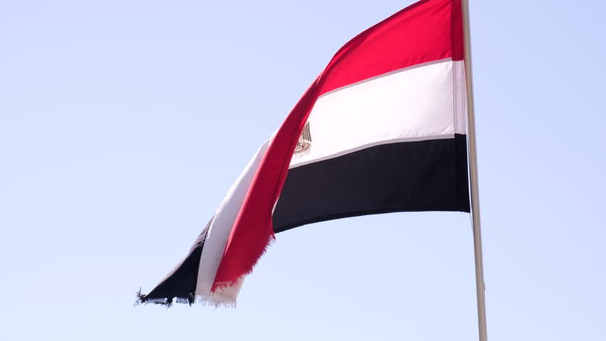Flag of Egypt waves against background blue sky