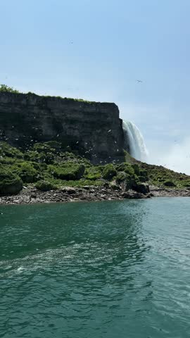 A majestic view of Niagara Falls with birds soaring over the misty waters, Ontario, Canada.
