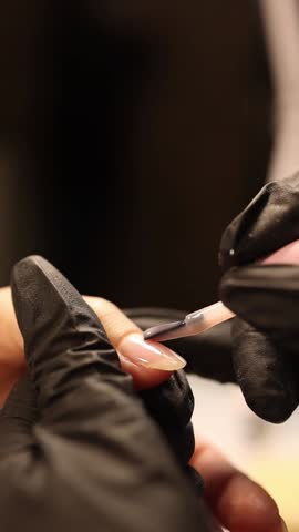 A manicurist does manicures in a beauty salon.
