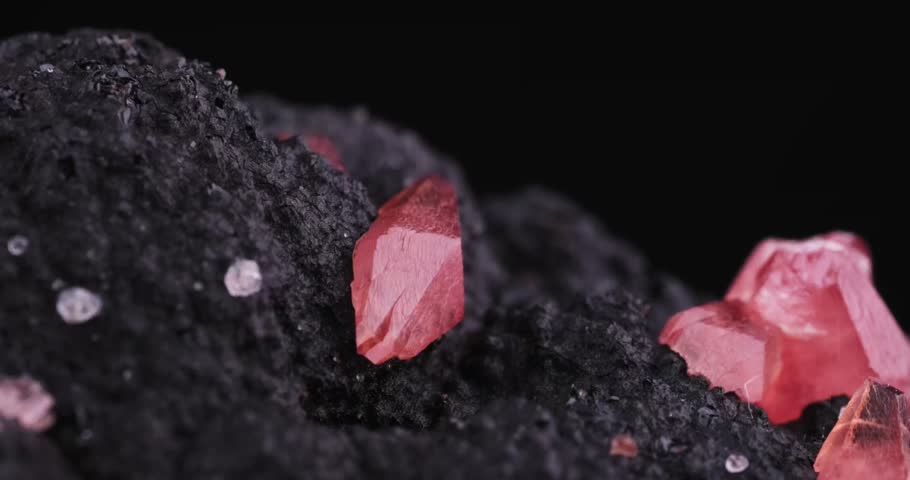 Rotating footage of a Rhodochrosite crystal. Specimen from Uchucchacua Mine, Oyón, Peru. macro photography detail texture background. close-up mineral crystal unpolished semi-precious gemstone