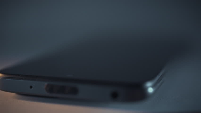 In darkness of night, smartphone screen illuminates, signaling incoming call. sudden ring tone breaks silence, announcing notification on the device, as the phone springs to life amidst the stillness