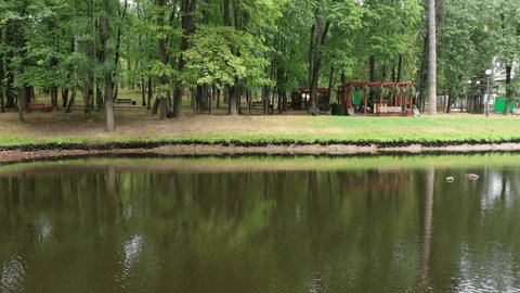 Drone Flying Backward over Park Pond