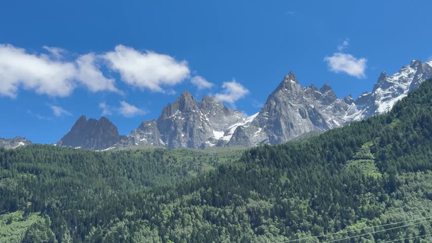 CHAMONIX, FRANCE - Panoramic view of the Alps as seen from Chamonix, showing snow-capped peaks, valleys, and mountain landscape under clear skies.