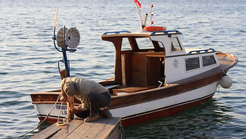 ISTANBUL - APRIL 7: Senior fisherman repairs wooden pier planks at Pasabahce