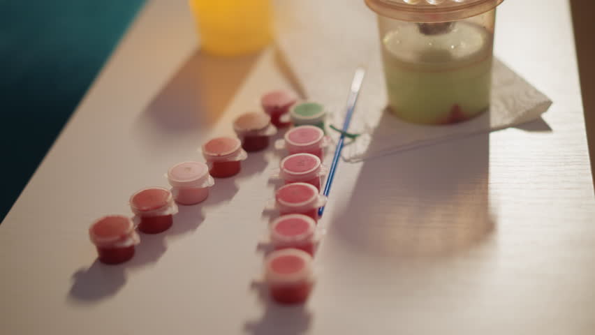 Paint Containers Aligned, Arrangement Of Tiny Paint Pots Next To Brushes And Mixing Vessel, Carefully Ordered Small Paint Containers Positioned Near Brushes And Blending Cup In Cozy Studio Setting