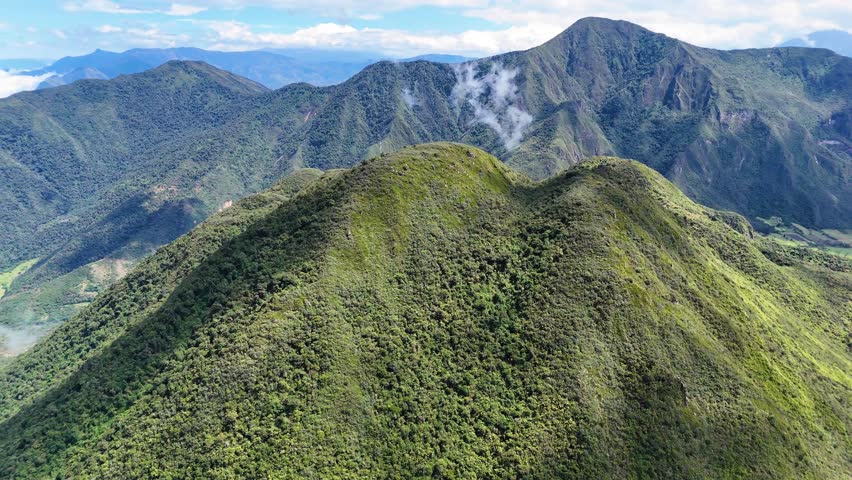 Aerial drone footage of the Pululagua volcano crater and surrounding mountains near Quito, Ecuador. Rare inhabited volcanic crater with lush vegetation and dramatic Andean scenery, ideal for nature documentaries, travel films and geological projects.
