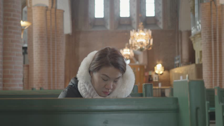A serene moment captured within an architectural space, featuring a person in quiet reflection. The setting evokes peace and introspection, offering a glimpse into a thoughtful pause amidst a beautifu