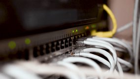 Server room rack with network cables. Network cables connect to server rack ports with blurry bokeh lights in the background. A close-up of a network rack with multiple Ethernet cables connected to it. Close-up network cables - Powered by Shutterstock - Get 15% off with code: PIKWIZARD15