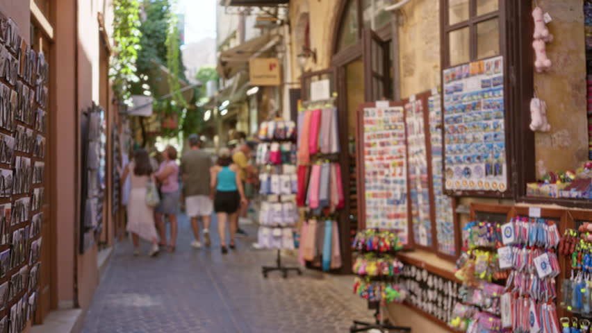 Narrow cobblestone market alley shop scene with blurred bokeh and soft defocused look, warm tones and shallow depth of field; background backplate copyspace.