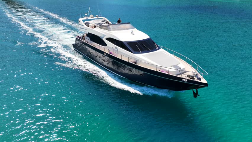 Aerial drone tracking video of luxury yacht cruising in deep blue open ocean sea