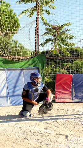 Young baseball batter powerfully hitting the ball during a practice game with the catcher ready to receive, showcasing a dynamic moment of sport, skill, and outdoor athletic competition