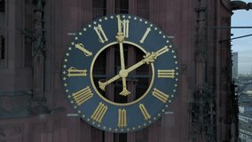 erial drone footage of Frankfurt Cathedral showing a detailed view of the clock tower with visible motion of the clock hands. Captured on a clear, sunny winter day at midday, emphasizing time passage and subtle movement in historic European architecture. - Powered by Shutterstock - Get 15% off with code: PIKWIZARD15