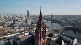 erial drone footage of Frankfurt Cathedral showing a detailed view of the clock tower with visible motion of the clock hands. Captured on a clear, sunny winter day at midday, emphasizing time passage and subtle movement in historic European architecture. - Powered by Shutterstock - Get 15% off with code: PIKWIZARD15