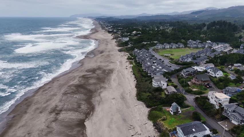 Aerial View of Oregon Coastline from Sandy Beach into the Pacific Ocean on a cloudy day.	Depoe Bay  