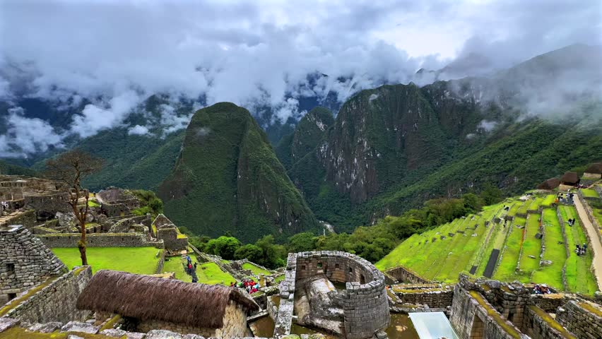 Machu Picchu circuit landscape view sunny cloudy morning Peru Perú aerial drone rainy season lush green jungle Peruvian Andes historic Inca Temple Sanctuary panoramic terrace layers static shot
