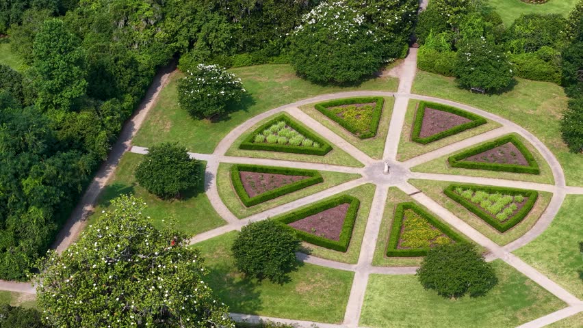 Aerial drone footage of a symmetrical circular garden at Middleton Place Plantation near Charleston, South Carolina. Radial paths divide manicured hedges and flower beds in a star-like design.