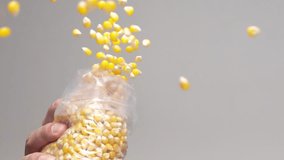 Hand dropping corn kernels from a plastic bag. Slow motion close up - Powered by Shutterstock - Get 15% off with code: PIKWIZARD15