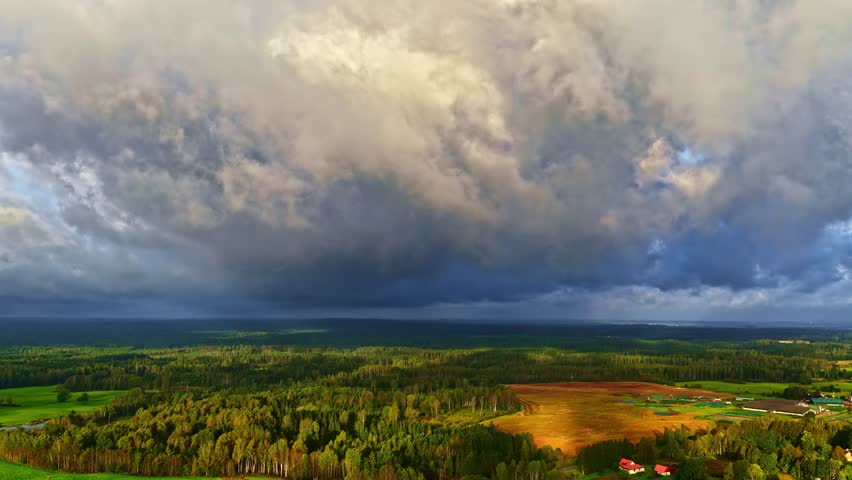 Rural landscape under dramatic storm clouds timelapse forest mixed canopy