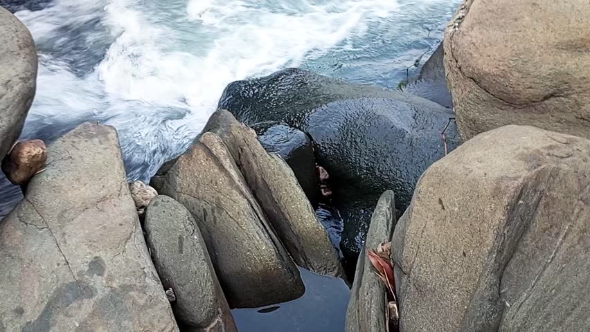 Natural Rocky Stream Waterfall Video - Scenic Mountain River Flowing Over Rocks for Relaxation, Travel Vlogs, and Nature Documentaries A breathtaking high-definition video of a natural rocky stream with a small cascading waterfall.